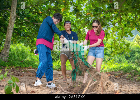 People of different nationalities cleaning garbage on the black beach to clean the beach in the world environment, volunteer concept Stock Photo