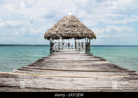 Wooden dock with palm roof along lake Itza, El Remate, Guatemala Stock Photo