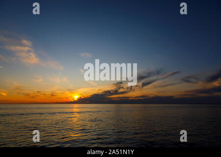 The sun sets in a colourful sunset over the Atlantic Ocean in good weather by Nantucket Island, Cape Cod, Massachusetts, New England, USA Stock Photo