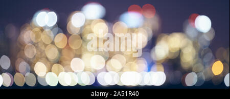 Color toned blurred city lights at night, urban abstract background. Stock Photo
