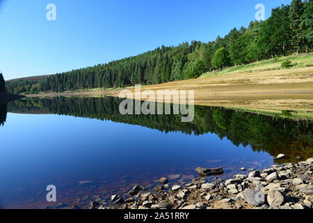 Howden reservoir derbyshire england, showing the sky and shores reflected in the still water in mid summer. Stock Photo