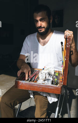 young painter teaches us his tools to work Stock Photo