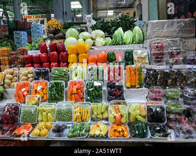 White cat selling fruits and vegetables in agricultural market. Stock Photo