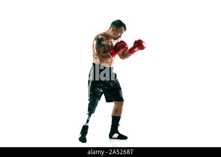 Full length portrait of muscular sportsman with prosthetic leg, copy space. Male boxer in red gloves. Isolated shot on white studio background. Stock Photo