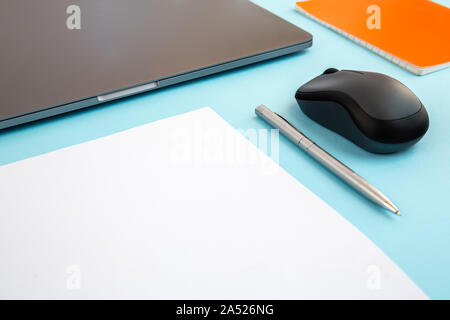 Minimal work desktop with laptop, blank white page with copy space, pen. Office mock up, empty document. Stock Photo