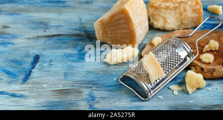 Aged parmesan cheese on a blue wooden table close up Stock Photo