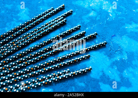 Black cocktail tube on a textural blue background for a festive drinks, festive background. Stock Photo