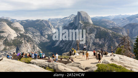 YOSEMITE, USA - SEPTEMBER 15, 2019 : Tourists admiring the views of Half Dome and the valley from  Glacier point in Yosemite National Park. Stock Photo