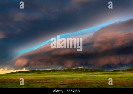 Dark storm clouds lead a dramatic, ominous thunderstorm over a scenic landscape near Lingle, Wyoming Stock Photo