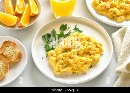 Scrambled eggs on plate over white stone background. Stock Photo