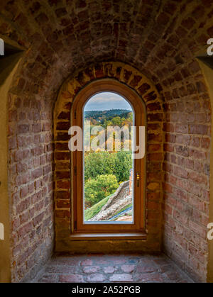 View through a window across fall colored trees in historic Gediminas tower in Vilnius, Lithuania Stock Photo