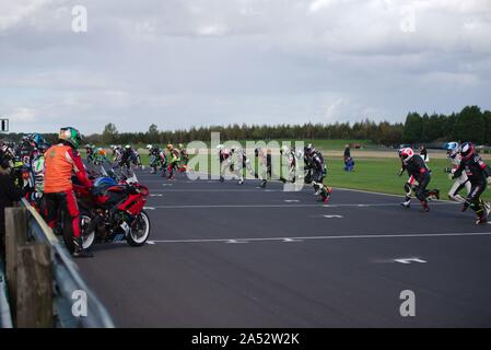 Dalton on Tees, England, 12 October 2019. Riders run across the track to their bikes at the start of their three hour endurance race during the No Limits meeting at Croft Circuit. Stock Photo