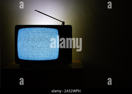 Old vintage television isolated on dark background with no signal and grainy noise effect on the screen. Retro TV Stock Photo