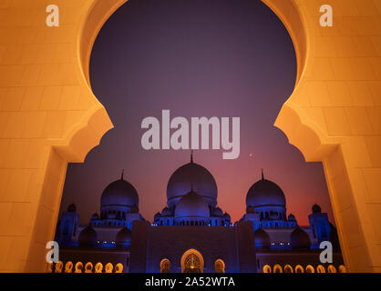 Framed grand mosque at Abu Dhabi at sunset with new moon Stock Photo