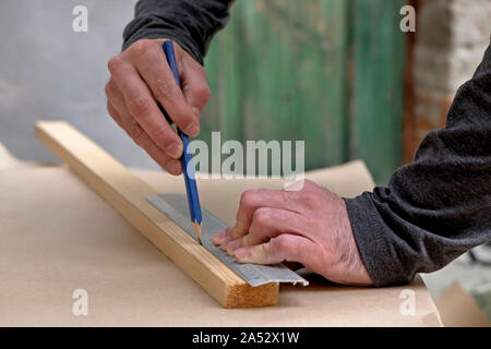 Carpenter drawing a line on a piece of wood Stock Photo