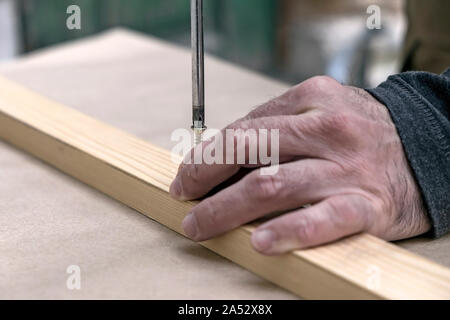 Carpenter tightening the screw in a piece wood Stock Photo