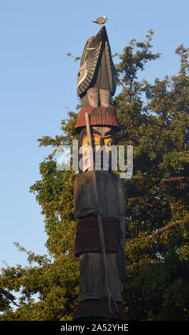 A seagull sits on the top of the Detail of the Knowledge Totem Pole outside the British Columbia Parliament Buildings. The totem pole was made by the Stock Photo