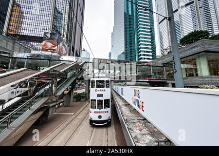 A historic double decker tram passes the Admiralty Center in the central district of Hong Kong. Stock Photo