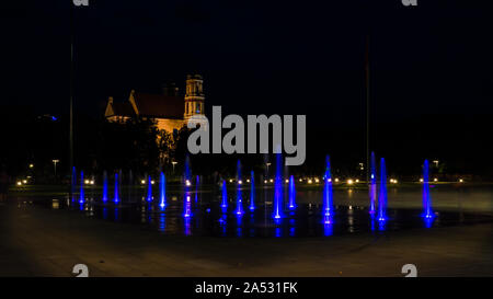 Colorful blue dancing fountains in a city square at night Stock Photo