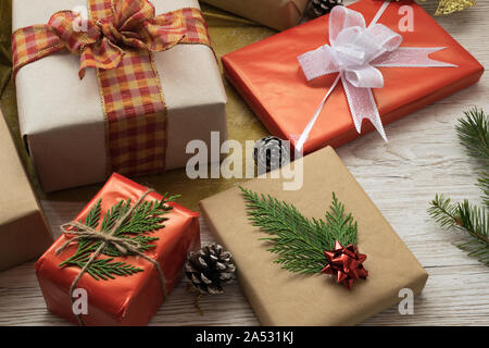 Overhead shot of multiple simple, lidded boxes tied with red raffia ribbon  bows and string. One has a blank tag for your message. Oak plank table bel  Stock Photo - Alamy