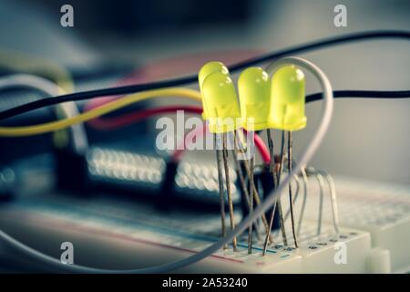 A portrait of an electronic circuit of LEDS on a breadboard with wires all around them. Stock Photo