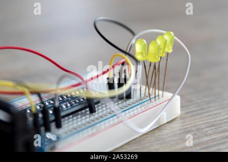 A portrait of an electronic circuit of LEDS on a breadboard with wires all around them and wired to a connection PCB of a raspberry pi. Stock Photo