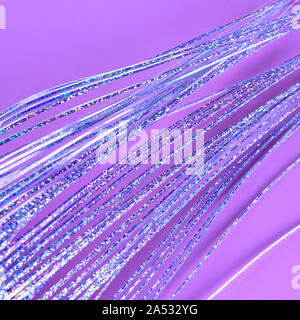 Pink background with holographic fantasy: magic mermaid hair, octopus, unicorn tail. Shiny sparkle abstract diagonal lines. Stock Photo