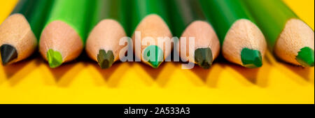 Vibrant banner with green sharpener pencils on yellow background. Education, business and writing concept. Selective focus. Banner template. Stock Photo