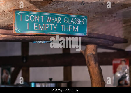 Funny inscription above the bar on a metal sign made of sheet painted green. Stock Photo