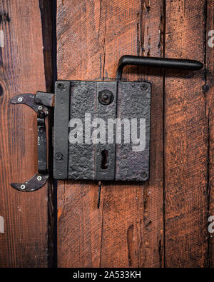 Old rusty door handle in a wooden door. Stock Photo