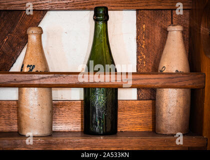Old beer bottles standing on a shelf in an abandoned country house. Stock Photo