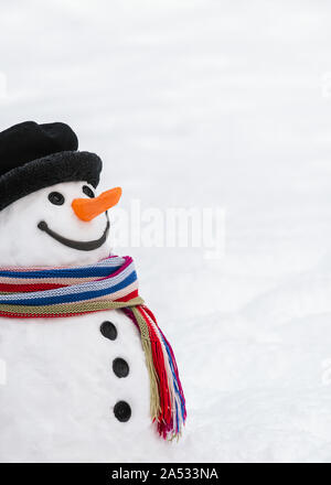 Cute snowman with a kind smile. Carrot nose, button eyes, twigs hands, snow body - a traditional winter character. Christmas and New Year card Stock Photo