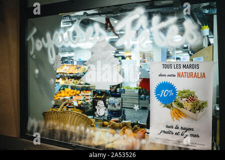 Strasbourg, France - Dec 2, 2017: Happy New Year inscription on the Naturalia Bio store in French city with special offer on fruits and vegetables minus 10 percents Stock Photo