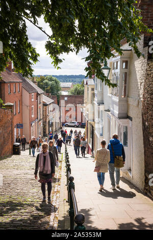 Tourists climbing up Steep Hill in Lincoln city England UK on a sunny September day Stock Photo