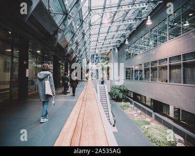 Strasbourg, France - Nov 23, 2017: Rear view of patients woman walking inside the NHC Nouvel Hopital Civil in Strasbourg large modern interiors Stock Photo