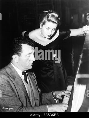 GRACE KELLY in Edith Head dress with vocal coach NORMAN LUBOFF on set candid during filming THE COUNTRY GIRL 1954 director George Seaton Perlberg - Seaton Productions / Paramount Pictures Stock Photo