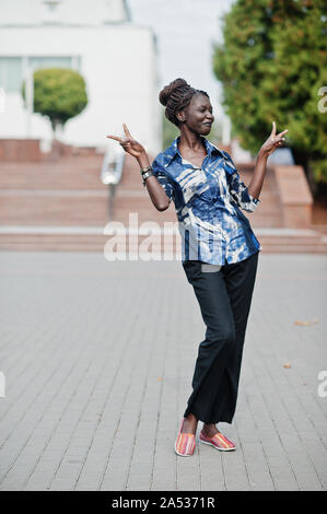 Young black female posed in the city. African women single portrait. She show two fingers. Stock Photo