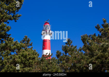 Vuurtoren, lighthouse of Ameland framed by green trees and blue sky in the background Stock Photo