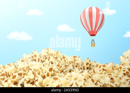 3d rendering of a filed covered with popcorn with a striped hot air balloon flying above it. Stock Photo