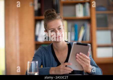 student learning in a library with tablet Stock Photo