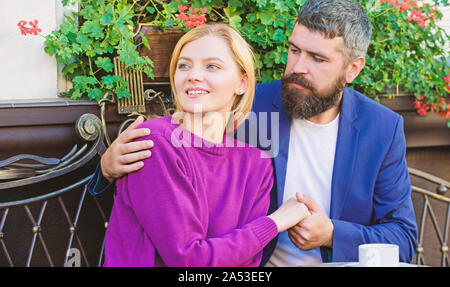 Couple in love sit cafe terrace enjoy coffee. Pleasant family weekend. Married lovely couple relaxing together. Travel and vacation. Explore cafe and public places. Couple cuddling cafe terrace. Stock Photo