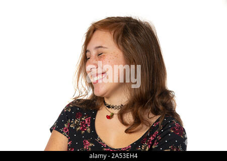 Horizontal studio shot of a pre-teen girl with freckles cracking up laughing.    Side view of her face.  Isolated on white. Stock Photo