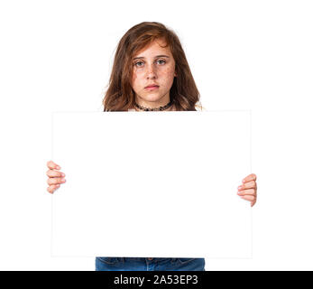 Horizontal studio shot of a serious looking pre-teen girl with freckles holding a blank white sign.  White background.  Copy space. Stock Photo