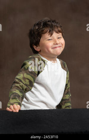 Vertical studio shot of a four-year-old little boy making a cute face.