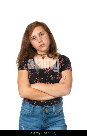 Vertical studio shot of a very irritated pre-teen girl with her arms crossed isolated on white. Stock Photo