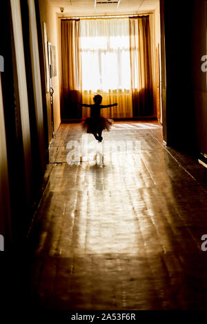 KHARKIV, UKRAINE - MARCH 6, 2019: Silhouette of a girl in a dark corridor Stock Photo