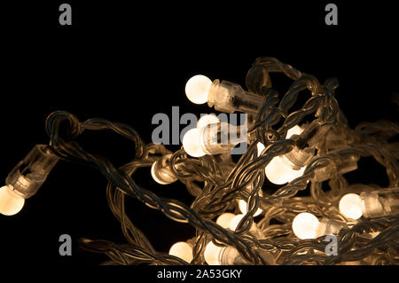 Closeup chain of white lights knotted black background by jziprian Stock Photo