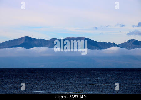 Scottish island shrouded in dense sea mist in autumn Stock Photo