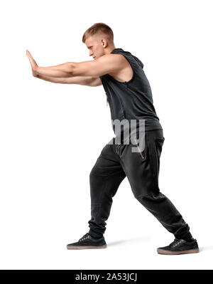 Side view of handsome muscled young man pushing something heavy isolated on white background Stock Photo