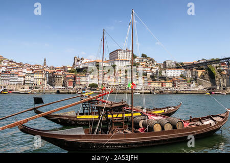 Porto and old traditional boats with wine barrels in Portugal with Dom Luis I Bridge in the background Stock Photo
